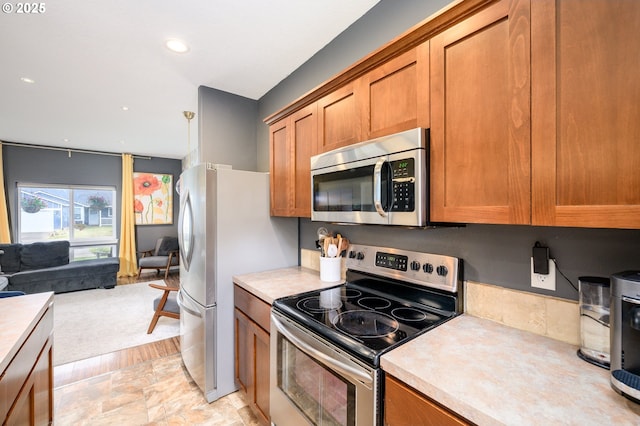 976 E 15th St, Lafayette, OR 97127 - kitchen with stainless steel appliances, brown cabinetry, light countertops, open floor plan, and recessed lighting