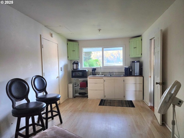3062 S Tenmile, Lakeside, OR 97449 - kitchen featuring green cabinetry, black microwave, light wood-style floors, and a sink
