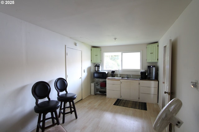 3062 S Tenmile, Lakeside, OR 97449 - kitchen featuring green cabinetry, light wood finished floors, black microwave, and a sink