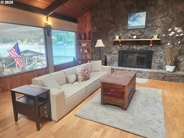 3062 S Tenmile, Lakeside, OR 97449 - living room featuring wooden ceiling, wood finished floors, a stone fireplace, and wood walls