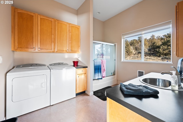 clothes washing area with cabinets, independent washer and dryer, and sink