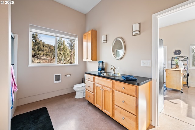 bathroom featuring toilet, concrete flooring, heating unit, and vanity