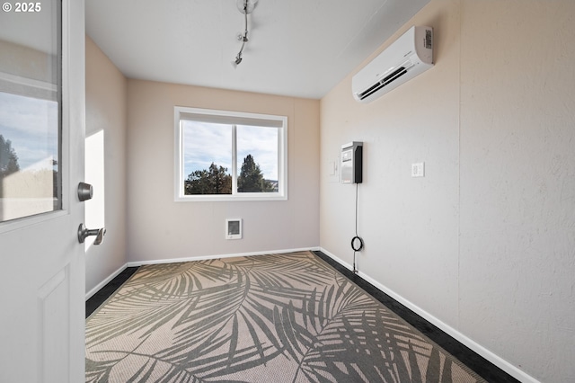 interior space with heating unit, a wall unit AC, and rail lighting