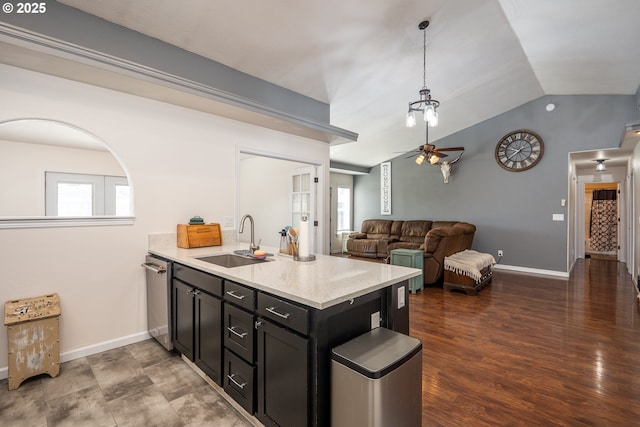 kitchen with a sink, plenty of natural light, a peninsula, and dark cabinets