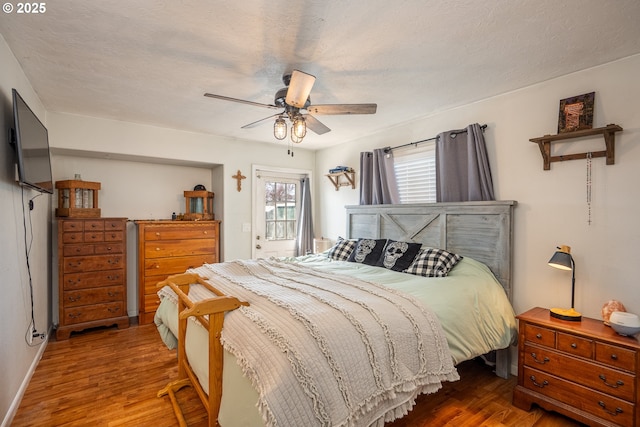 bedroom featuring a textured ceiling, ceiling fan, and wood finished floors