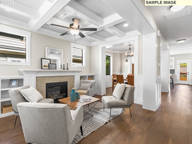 living room with beam ceiling, a brick fireplace, and coffered ceiling