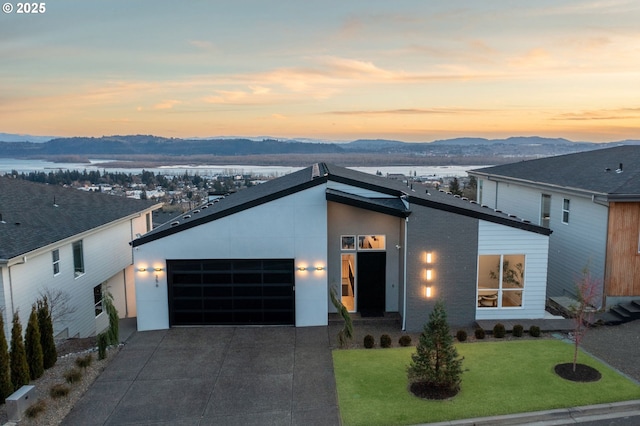 contemporary house with a lawn, a garage, and a mountain view