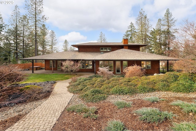 view of front of property featuring a patio and a chimney