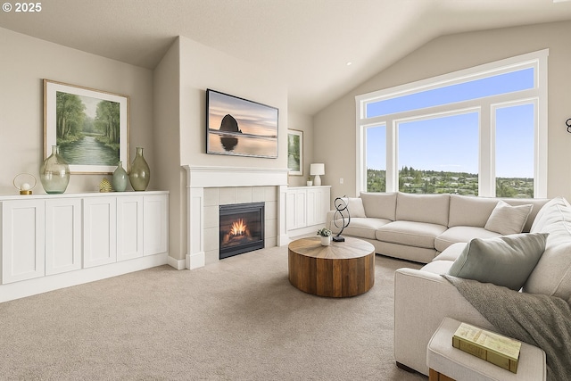 carpeted living area with vaulted ceiling and a tile fireplace
