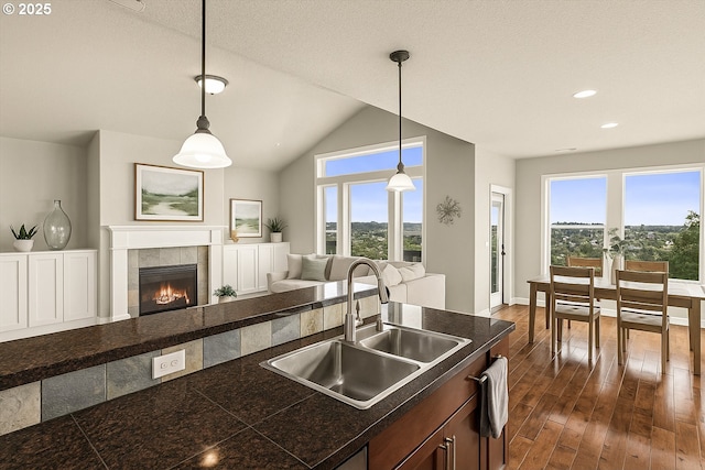 kitchen featuring a sink, open floor plan, tile counters, healthy amount of natural light, and recessed lighting
