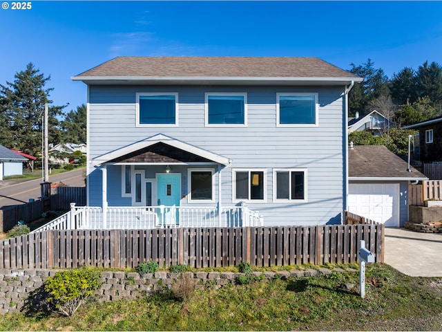 view of front of house with driveway, a garage, a fenced front yard, and a shingled roof