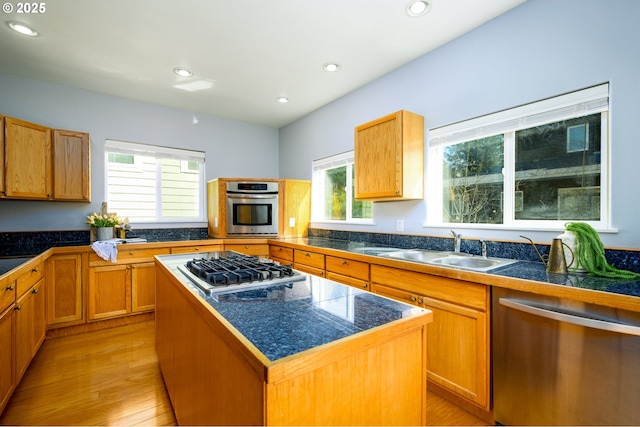 kitchen featuring a sink, tile counters, light wood-type flooring, and appliances with stainless steel finishes