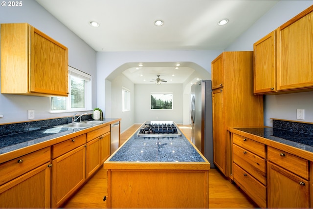 kitchen with tile countertops, recessed lighting, a kitchen island, and appliances with stainless steel finishes