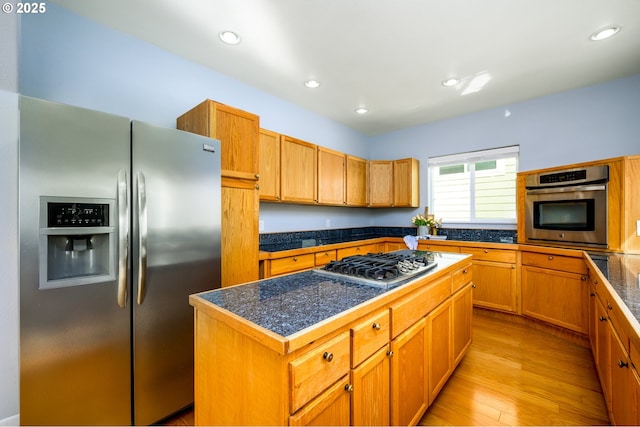 kitchen featuring light wood finished floors, recessed lighting, appliances with stainless steel finishes, tile countertops, and a center island