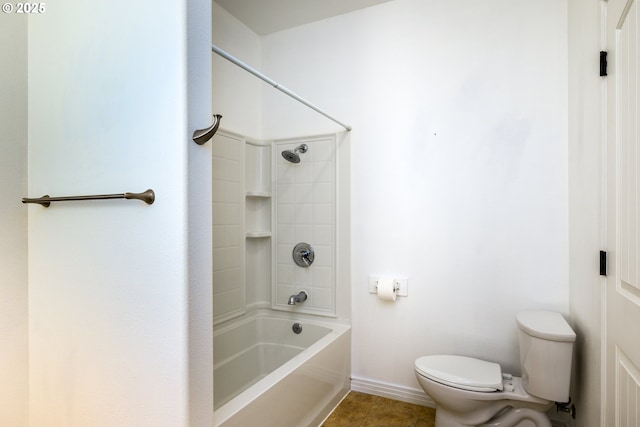 bathroom featuring baseboards, toilet, tile patterned floors, and shower / washtub combination