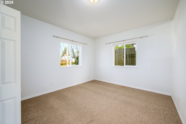 carpeted spare room with baseboards