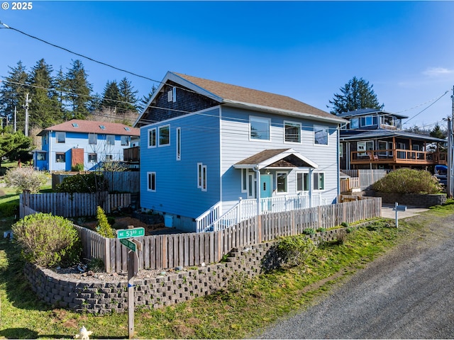 view of front of home featuring fence and roof with shingles
