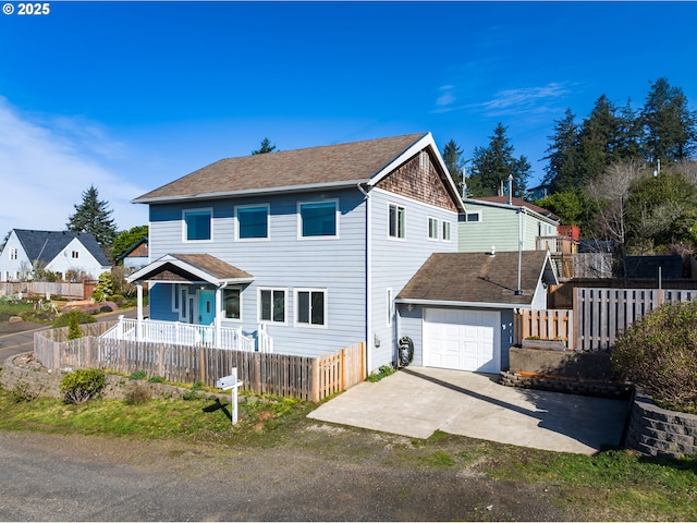 view of front of home featuring a shingled roof, driveway, a fenced front yard, and a garage