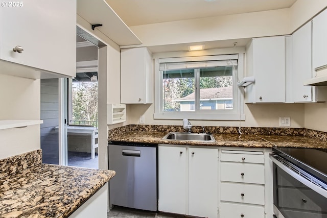 kitchen with sink, dark stone counters, white cabinets, and appliances with stainless steel finishes