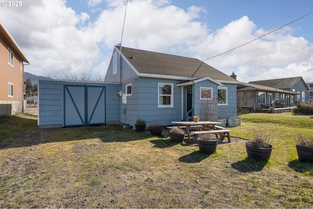 rear view of property with a storage shed and a lawn