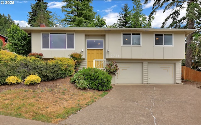 3765 Potter St, Eugene, OR 97405 - raised ranch with concrete driveway, an attached garage, board and batten siding, and a chimney
