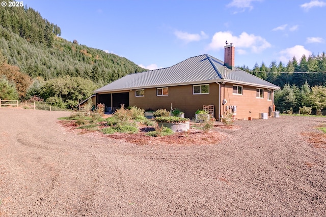 9602 Harlan Rd, Eddyville, OR 97343 - view of property exterior with a standing seam roof, a chimney, and metal roof