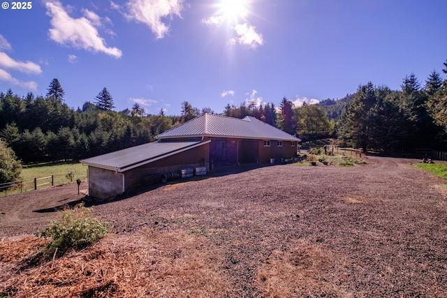 9602 Harlan Rd, Eddyville, OR 97343 - view of side of home featuring a view of trees, fence, and metal roof