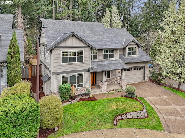 12955 SW Oxalis Ter, Portland, OR 97223 - view of front of home with stone siding, roof with shingles, concrete driveway, and a garage