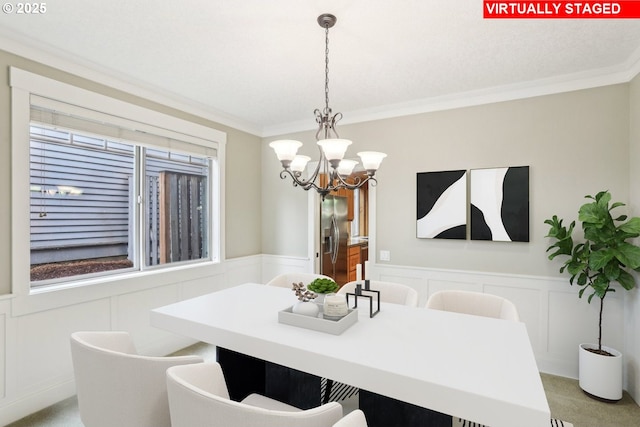 12955 SW Oxalis Ter, Portland, OR 97223 - dining room with a decorative wall, a chandelier, crown molding, wainscoting, and light carpet