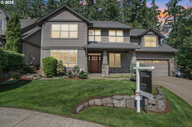 12955 SW Oxalis Ter, Portland, OR 97223 - craftsman house featuring driveway, a yard, stone siding, roof with shingles, and covered porch