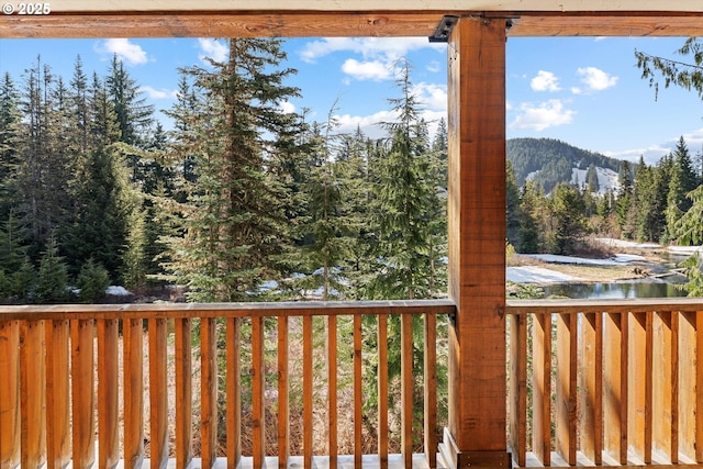 wooden deck with a view of trees and a mountain view
