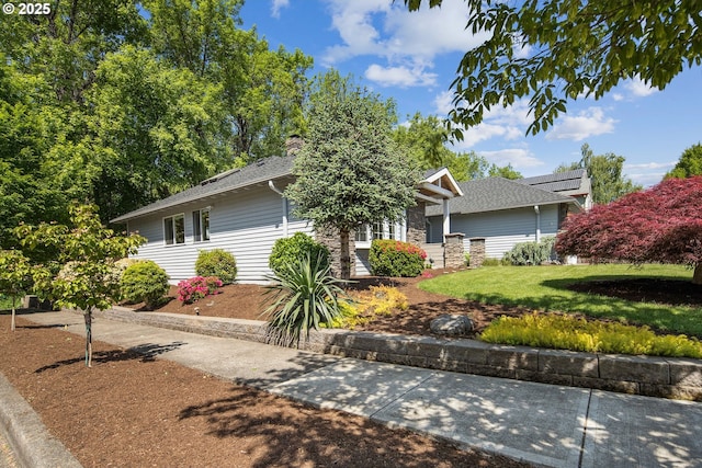 obstructed view of property featuring a front lawn, a chimney, and stone siding