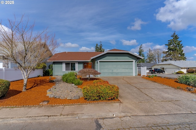 ranch-style house featuring concrete driveway, fence, and a garage