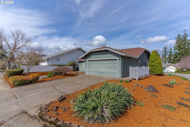 ranch-style house featuring concrete driveway, a garage, and fence