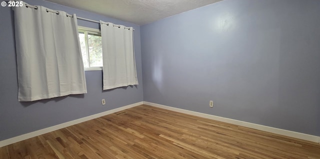 14128 NE Rose Pkwy, Portland, OR 97230 - empty room with wood finished floors and a textured ceiling