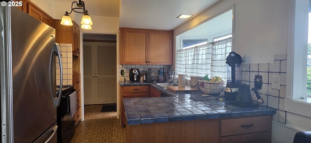 14128 NE Rose Pkwy, Portland, OR 97230 - kitchen featuring freestanding refrigerator, brown cabinetry, and healthy amount of natural light