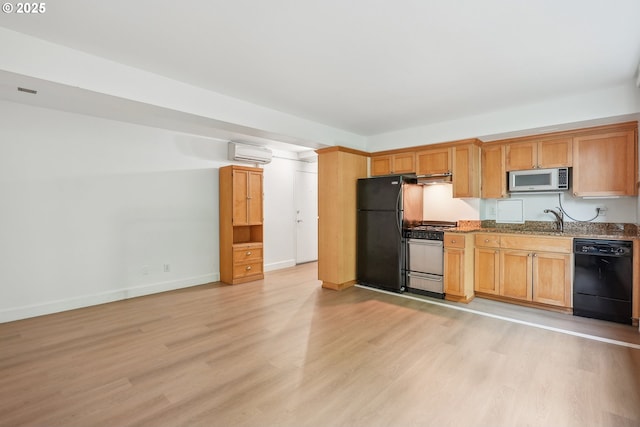 1205 SW Cardinell Dr Unit 604, Portland, OR 97201 - kitchen with black appliances, an AC wall unit, light wood finished floors, a sink, and stone countertops