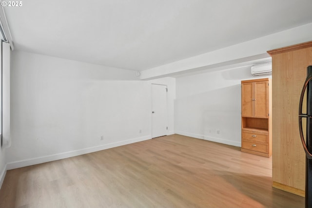 1205 SW Cardinell Dr Unit 604, Portland, OR 97201 - unfurnished room with a wall mounted AC, light wood finished floors, and baseboards