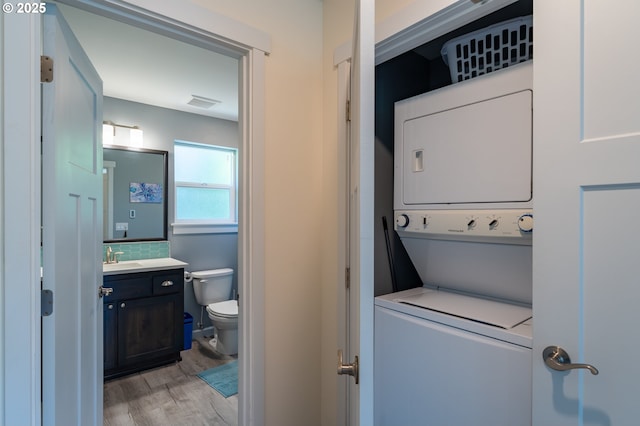 510 SE 130th Dr, Newport, OR 97366 - laundry room featuring stacked washing machine and dryer and light wood-style flooring