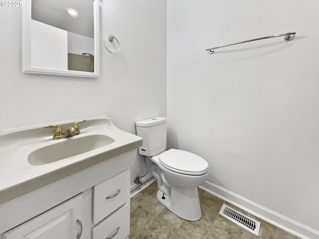 bathroom with vanity, toilet, baseboards, and visible vents