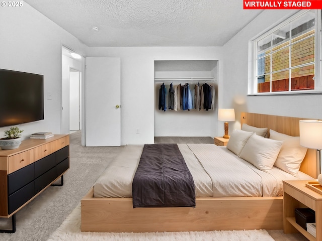 carpeted bedroom with a closet and a textured ceiling