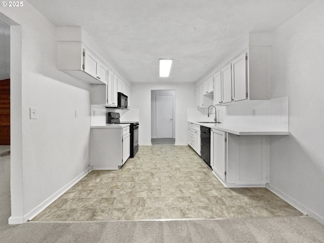 kitchen with black appliances, baseboards, light countertops, white cabinetry, and a sink