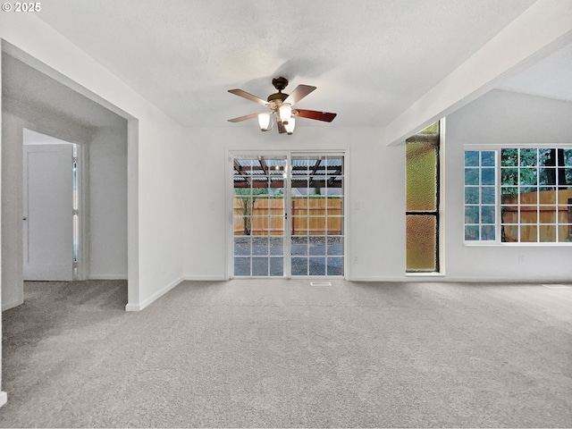 unfurnished room featuring baseboards, carpet, ceiling fan, and a textured ceiling