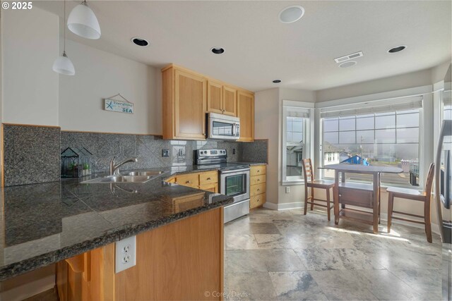 168 N Pacific St, Rockaway Beach, OR 97136 - kitchen featuring appliances with stainless steel finishes, a sink, dark countertops, tasteful backsplash, and recessed lighting