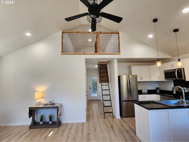 kitchen with dark countertops, light wood-type flooring, white cabinetry, stainless steel appliances, and high vaulted ceiling