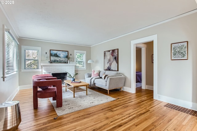 living room featuring a fireplace, light wood-style floors, and baseboards