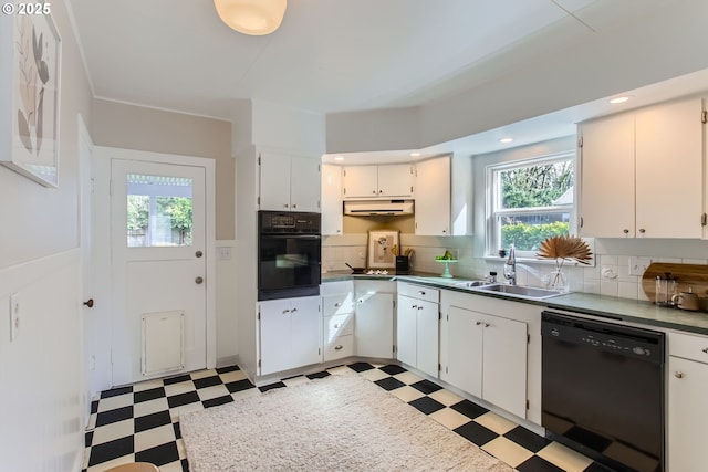 kitchen featuring under cabinet range hood, light floors, black appliances, and a sink