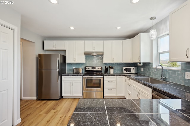 315 W 13th St, The Dalles, OR 97058 - kitchen with appliances with stainless steel finishes, a sink, under cabinet range hood, tile counters, and white cabinetry