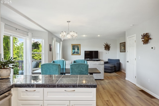 315 W 13th St, The Dalles, OR 97058 - kitchen featuring tile countertops, a chandelier, white cabinetry, light wood-style floors, and recessed lighting