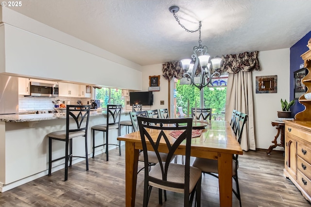 1473 N Locust St, Canby, OR 97013 - dining room featuring a chandelier, dark wood finished floors, and a textured ceiling